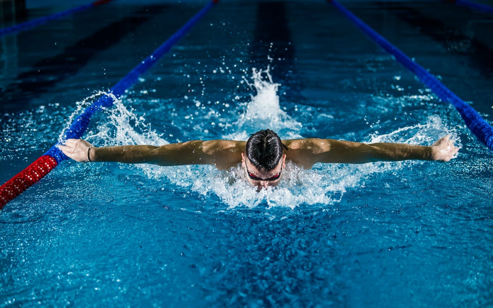 Kinder lernen Schwimmen in einem Schwimmschul-Becken